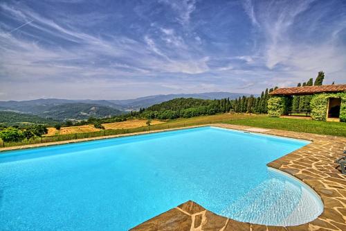 an image of a swimming pool in front of a house at Villa Poggio dei Cipressi in Subbiano