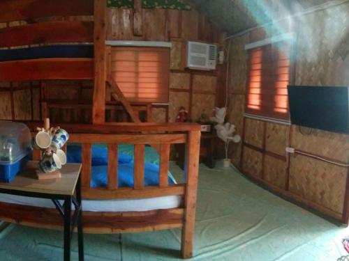 een slaapkamer met een stapelbed en een tafel bij HAVEN BREEZE RESORT - A home of Hundred Islands in Alaminos
