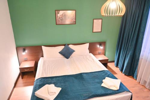 a bedroom with a bed with a green wall at Hotel Ida in Bansko