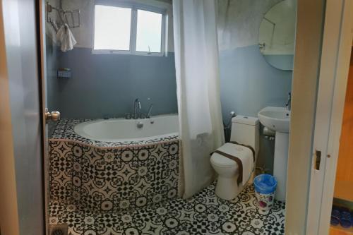 a bathroom with a tub and a toilet at Rick Resort Teluk Intan in Teluk Intan