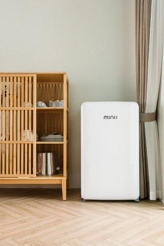 a small refrigerator in a room next to a shelf at Baan Tah On The Sea in Bang Sare