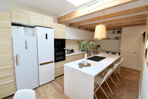 une cuisine avec un réfrigérateur blanc et une table dans l'établissement Luberon - Air-conditioned apartment, à Le Puy-Sainte-Réparade