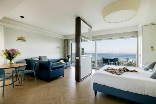 a hotel room with a bed and a view of the ocean at BeSUITE Apartments in San Benedetto del Tronto