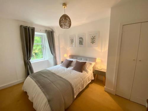 a bedroom with a bed and a window at Knockfarrie Cottage in Pitlochry