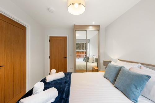 1 dormitorio con 1 cama blanca grande con almohadas azules en Rock Mill Apt 1 with Terrace, en Stony Middleton