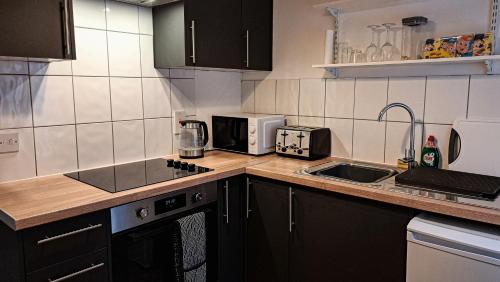 a kitchen with a counter with a sink and a microwave at The Old Vicarage in Flore