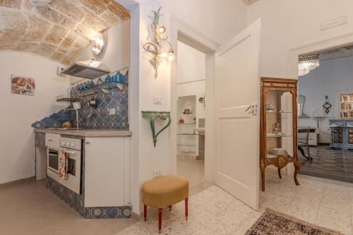 a kitchen with a stove and a chair in a room at Palazzo Extravacanza in Polignano a Mare