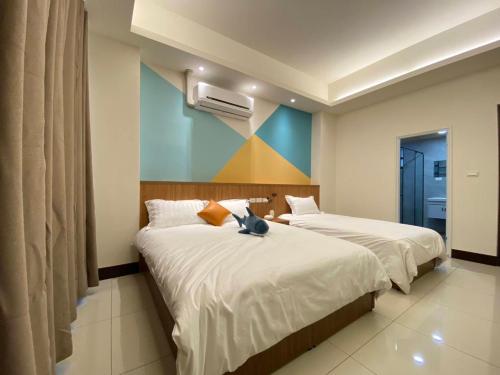 a bedroom with two beds with a cat sitting on them at The sun never sets B&B in Budai
