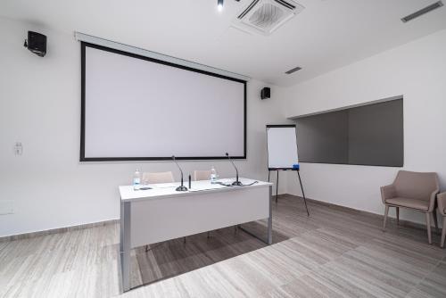 a white room with a large projection screen and a chair at Miramare Hotel in Zadar