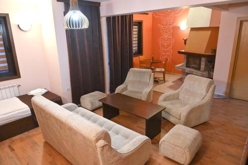 a living room with a couch and chairs and a table at Hotel Ida in Bansko