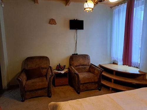 - une chambre avec deux chaises, une table et un lit dans l'établissement Apartamenty Kluśka, à Zakopane