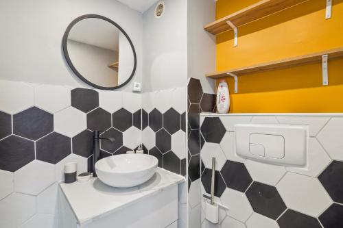 een badkamer met een wastafel en een spiegel bij Chic and comfortable studio in Amiens