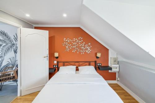 een slaapkamer met een bed met een oranje muur bij Chic and comfortable studio in Amiens