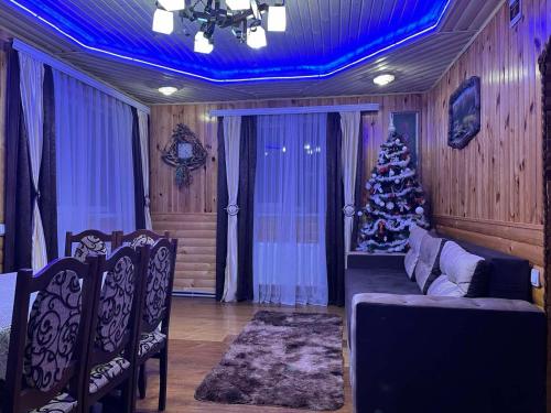 - un salon avec un arbre de Noël et un canapé dans l'établissement Сімейний котедж КРАЄВИД, à Mykulychyn