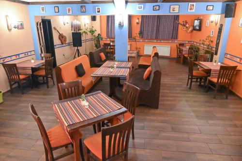 a restaurant with tables and chairs and a fireplace at Hotel Ida in Bansko