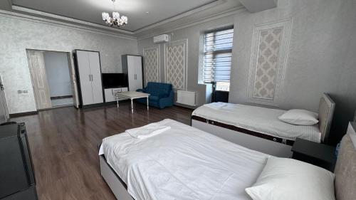 Habitación de hotel con 2 camas y TV en Parvoz Hotel, en Urganch