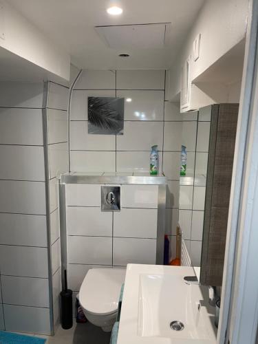 bagno con servizi igienici bianchi e lavandino di Studio entièrement équipé à 10 min de La Défense a Suresnes