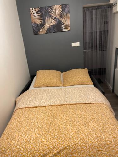 un letto in una camera con due cuscini sopra di Studio entièrement équipé à 10 min de La Défense a Suresnes