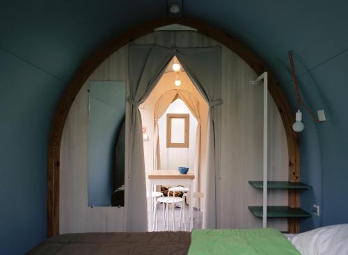 sypialnia z łukiem ze stołem i krzesłem w obiekcie Camping Onlycamp La Potinière w mieście Écueillé