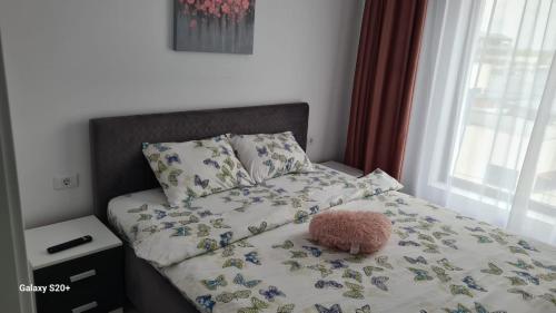 uma cama com um bicho de peluche sentado em cima dela em Apartament Lucian em Râmnicu Vâlcea
