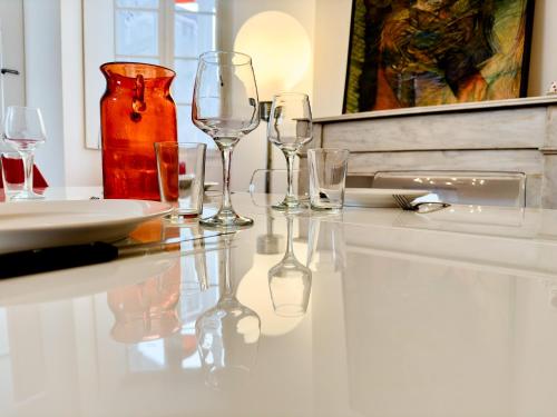una mesa con copas de vino y un jarrón en ella en Superbe Appartement Hypercentre - L'Artistique, en Pau