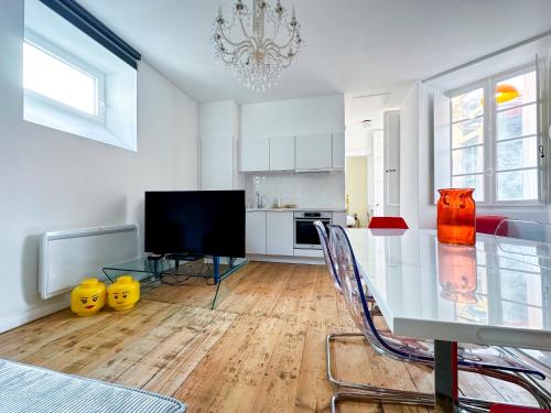une salle à manger avec une table en verre et une télévision dans l'établissement Superbe Appartement Hypercentre - L'Artistique, à Pau