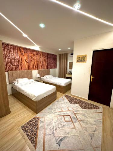 a hotel room with two beds and a rug at Locanda pyramids view in Cairo