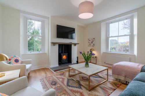 a living room with a couch and a fireplace at Deer Park Farmhouse in Lydney