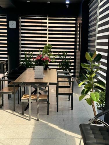 a wooden table and chairs in a room with plants at Safarov's Family Hostel in Tashkent