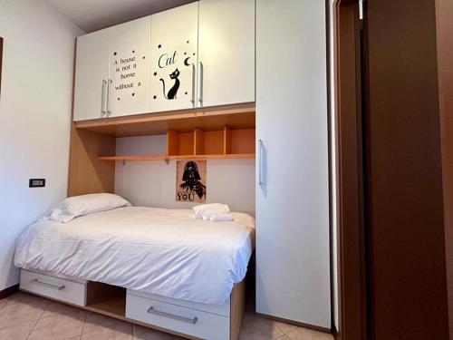 a small bedroom with a bed and white cabinets at Kibilù - Residence with Pool, near Lake Maggiore in  Monvalle 