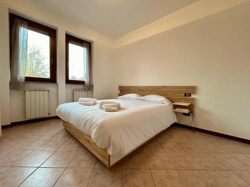 a bedroom with a large bed with two towels on it at Kibilù - Residence with Pool, near Lake Maggiore in  Monvalle 