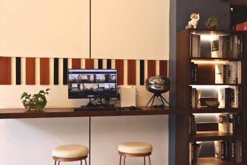 a room with a desk with a computer and two stools at CDX RESIDENCE in Phnom Penh