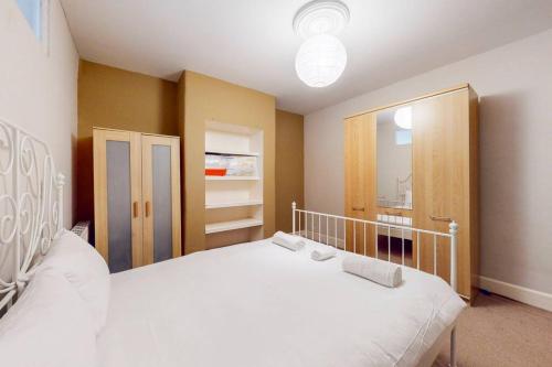 1 dormitorio con 1 cama blanca grande y espejo en Charming 1BD flat with a private garden in Leyton en Londres