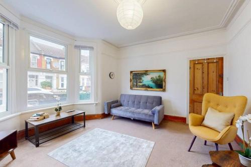 a living room with a blue couch and a table at Charming 1BD flat with a private garden in Leyton in London
