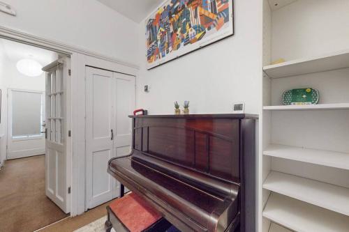 a hallway with a piano in a room at Charming 1BD flat with a private garden in Leyton in London