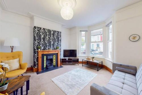 a living room with a couch and a fireplace at Charming 1BD flat with a private garden in Leyton in London