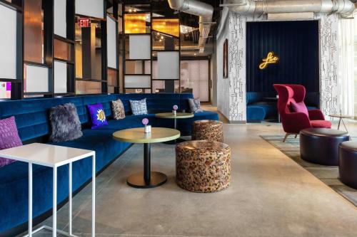 a lobby with a blue couch and chairs and tables at Aloft Orlando Lake Buena Vista in Orlando