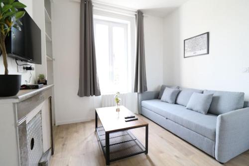 un salon avec un canapé et une table dans l'établissement Le Logis de la Gare - 4 min à pied de la gare, à Bourg-en-Bresse