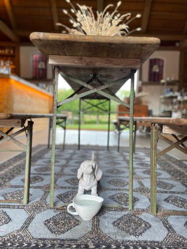 a small elephant standing under a table with a cup at Ekenäs Gård på Österlen in Kivik