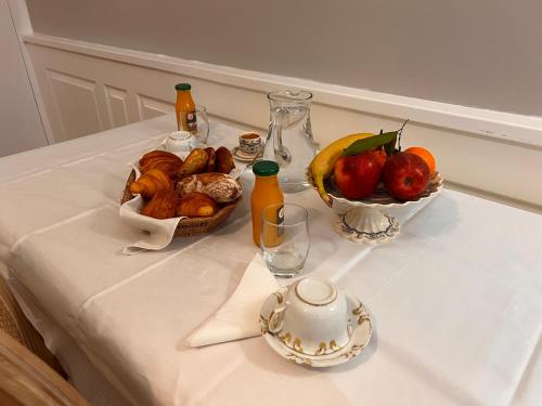 ein Tisch mit einer Schale Obst und einem Krug Saft in der Unterkunft Le manoir de la Cane in Montfort-sur-Meu