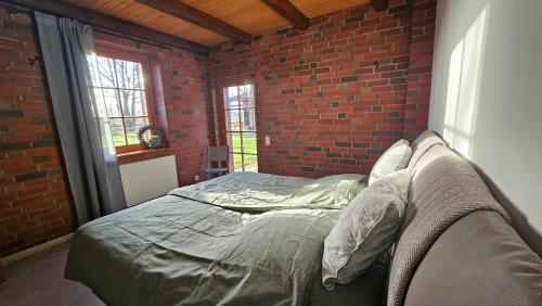 a bedroom with a brick wall and a bed at 3 Zi. 30 Min. von Hamburg, Landhaus Wohnung in Klein Offenseth-Sparrieshoop