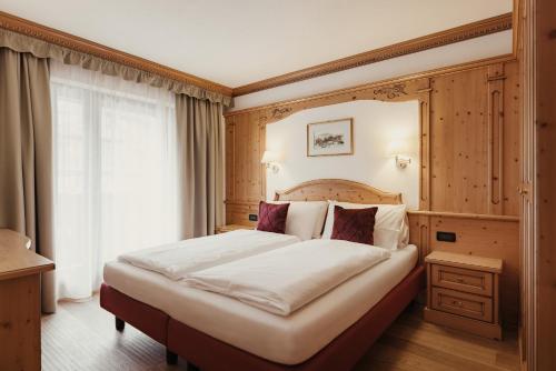 A bed or beds in a room at Diana Dolomites Living & Taste