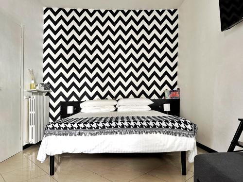1 dormitorio con una pared a cuadros en blanco y negro en Il Bumbunin Esclusivo monolocale nel cuore di Asti en Asti