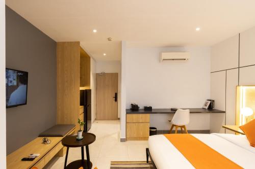 a bedroom with a bed and a desk and a kitchen at CDX RESIDENCE in Phnom Penh