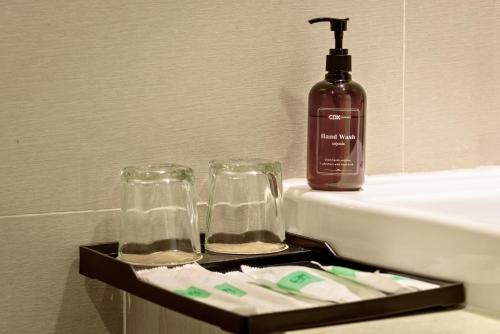 a tray with two glasses and a bottle of soap at CDX RESIDENCE in Phnom Penh