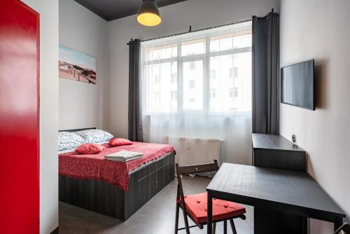 1 dormitorio con cama, mesa y ventana en 110 Hostel, en Gdynia