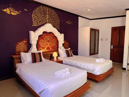 a bedroom with two beds with white sheets at Phiphu Art and Gallery Boutique Sukhothai in Sukhothai