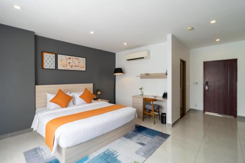 a bedroom with a large bed and a desk at CDX RESIDENCE in Phnom Penh