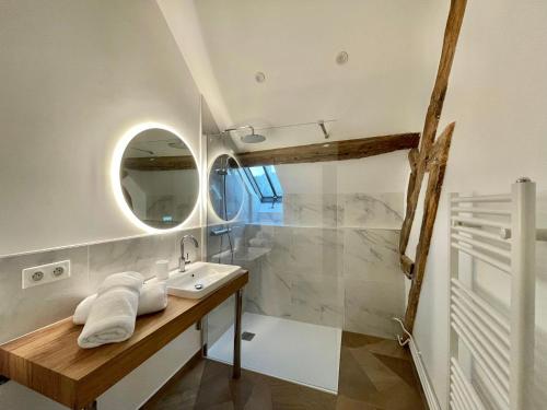 a bathroom with a sink and a mirror at La Demeure des Hôtes 10 minutes de Disney in Couilly-Pont-aux-Dames