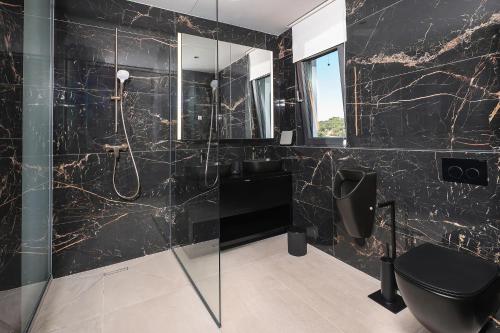 a black bathroom with a shower and a toilet at Luxury villa del Sol in Novalja